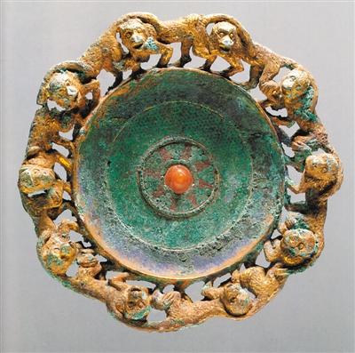 云南石寨山滇人墓出土《鎏金铜扣饰》。